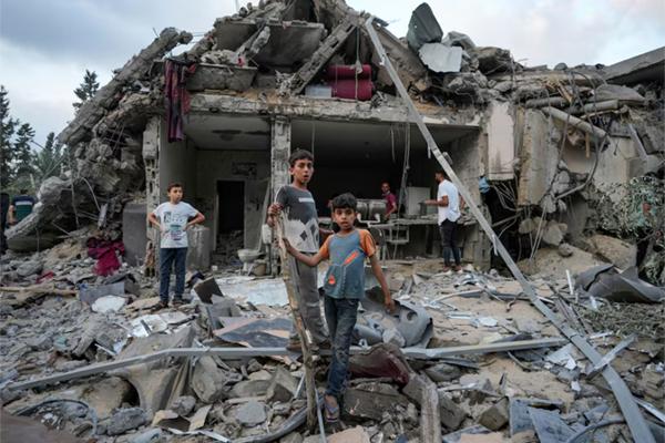 Palestinians look at the destruction after an Israeli airstrike in Deir al Balah, Gaza Strip, on April 30. (Abdel Kareem Hana/AP)